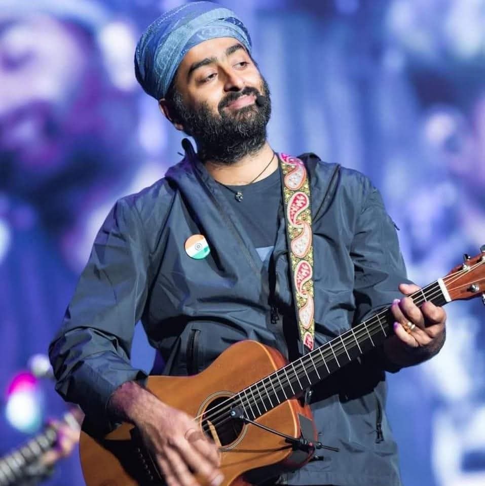 Arijit Singh performing live on stage with a guitar in Chandigarh in 2025